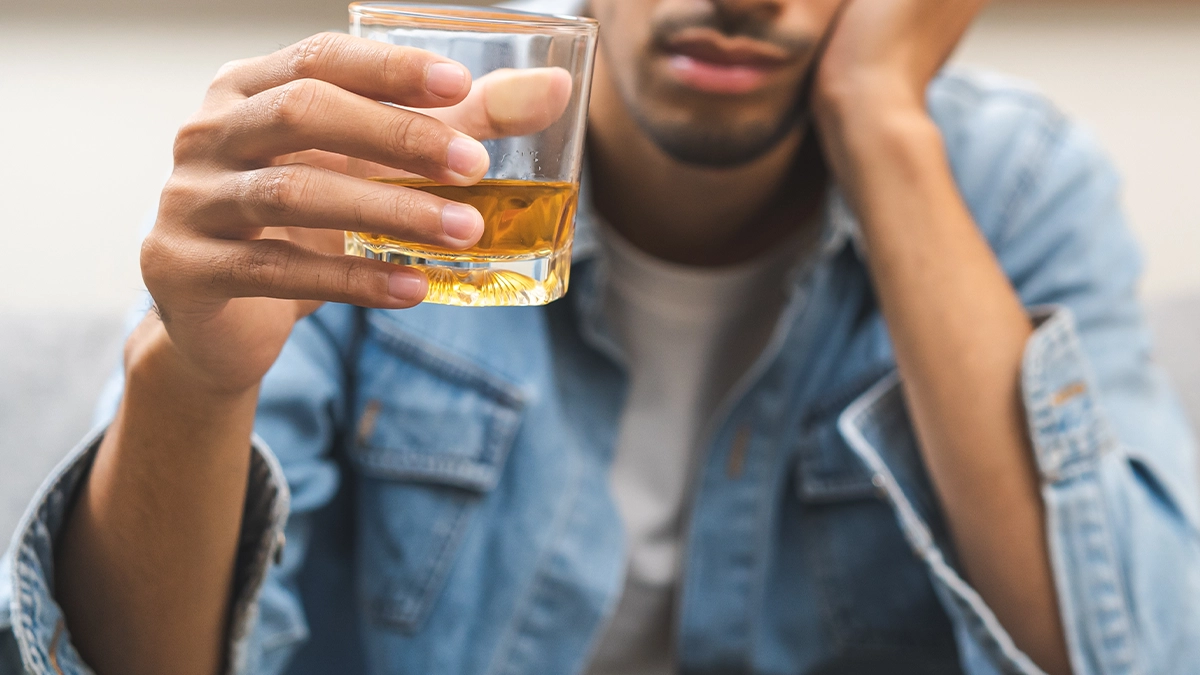 man with a glass of alcohol in his hand