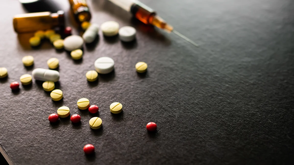 a multicolor assortment of pills spilled on a a table