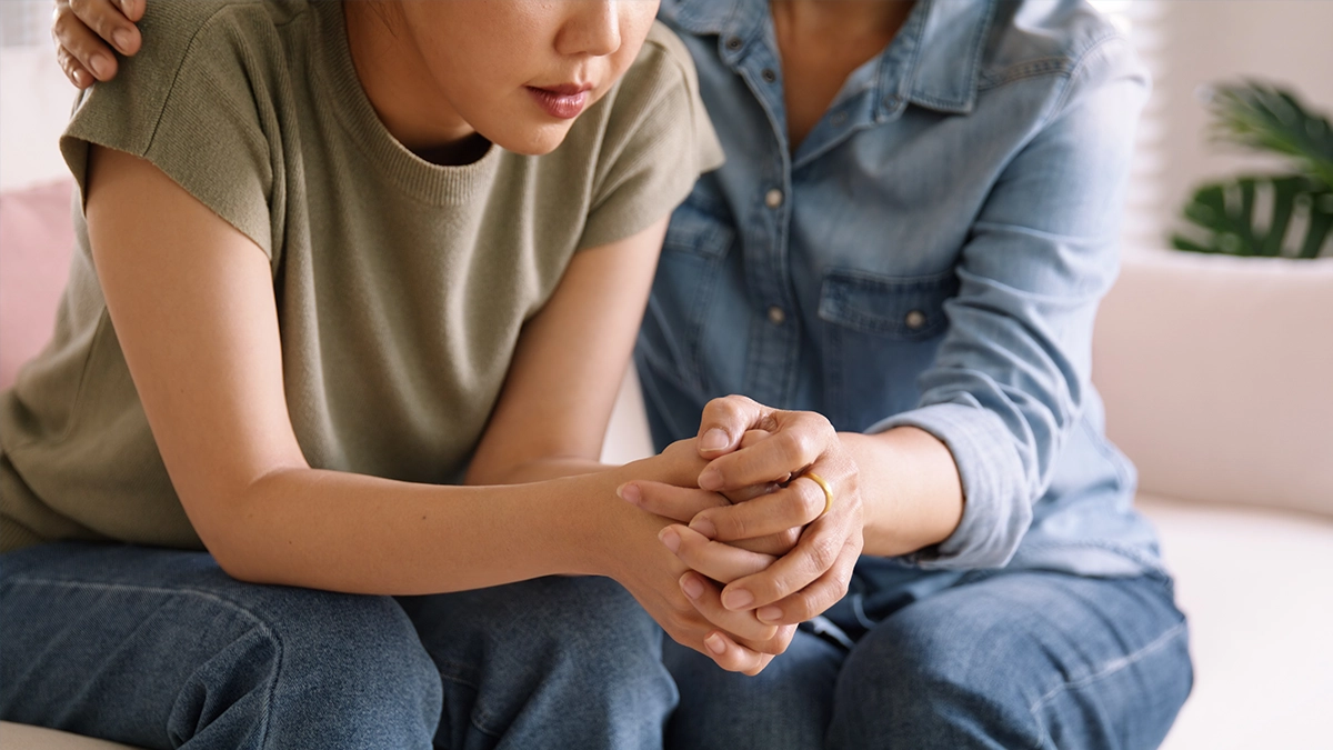 woman consoling her distressed daughter