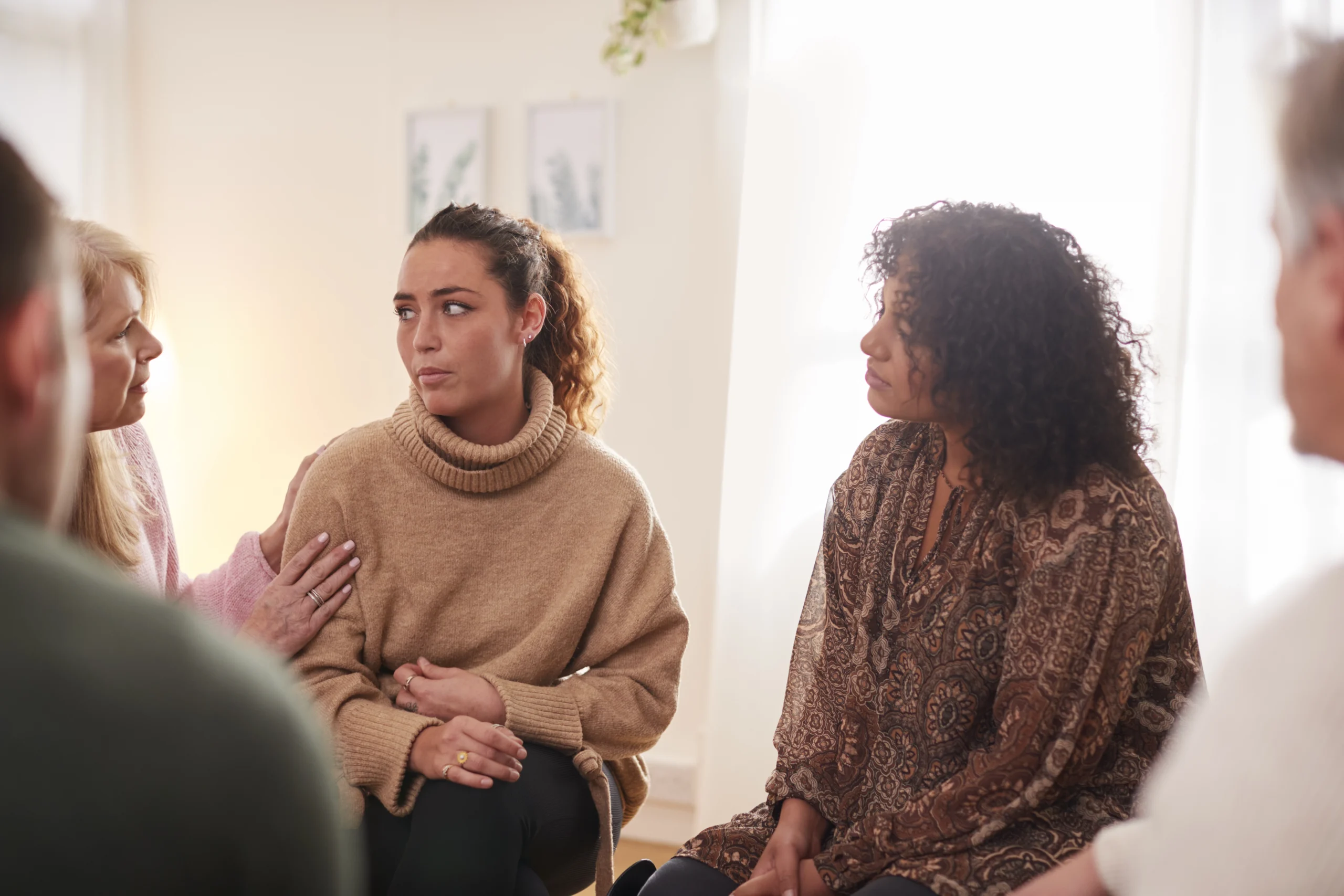 A comforting environment in an inpatient mental health facility, with supportive healthcare professionals assisting patients.