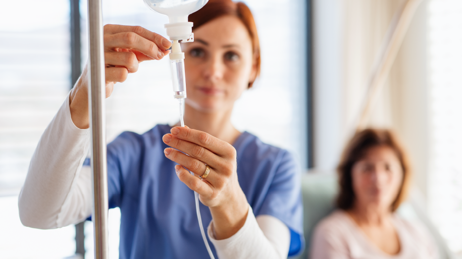 Woman smiling and sitting in a comfortable chair while receiving IV treatment.