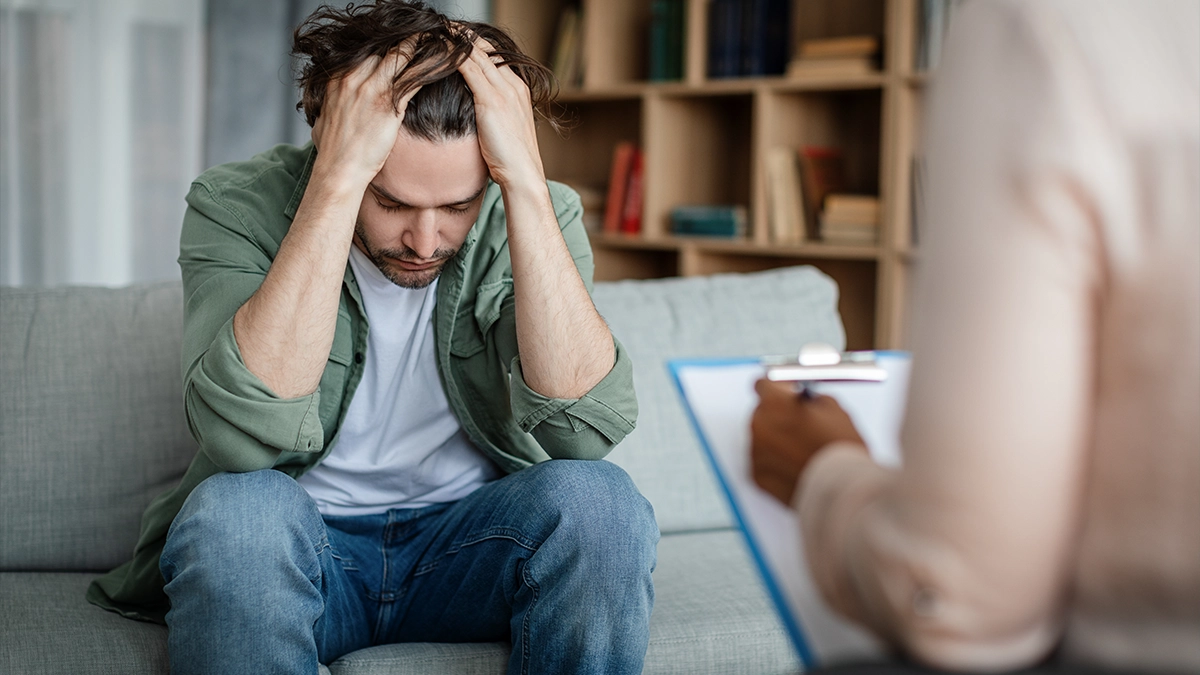 distressed man with his hands pressed on his head